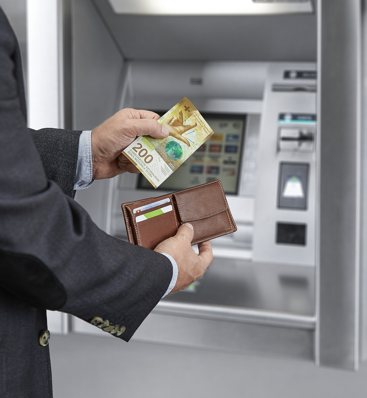 200-franc notes being withdrawn from an ATM